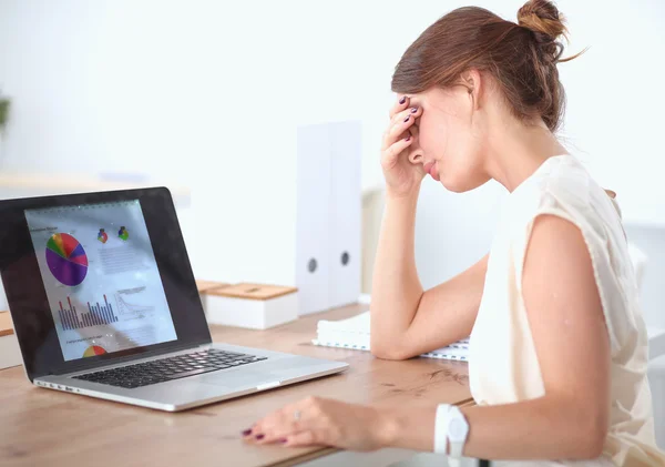 Retrato de una joven mujer de negocios cansada con computadora portátil en la oficina —  Fotos de Stock