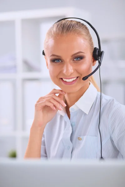 Retrato de una hermosa mujer de negocios trabajando en su escritorio con auriculares y laptop — Foto de Stock