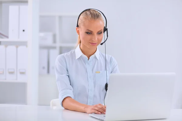 Porträtt av vacker affärskvinna arbetar på hennes skrivbord med headset och laptop — Stockfoto