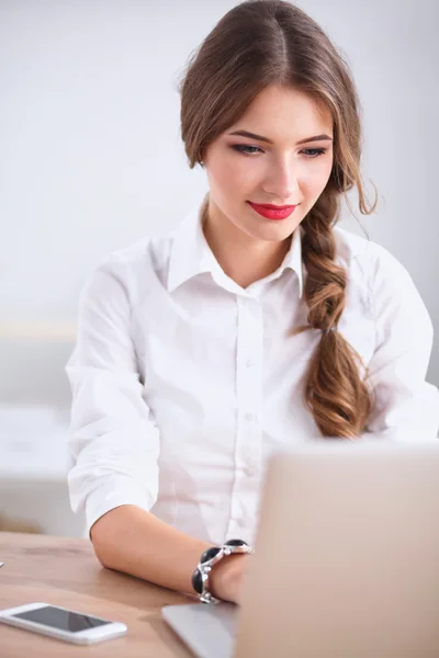 Attraktive Geschäftsfrau sitzt auf Schreibtisch im Büro — Stockfoto