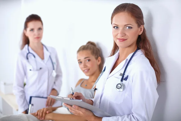 Smiling female doctor with a folder in uniform standing at hospital Stock Image