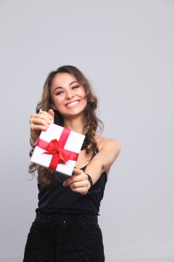 genç kadın mutlu gülümseme hediye kutusu gri arka plan üzerinde izole elinde tut