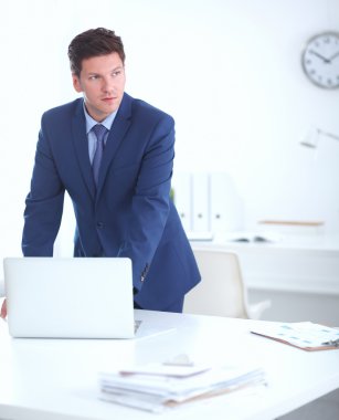 Kendine güvenen başarılı genç işadamı eğilimli silah masasının üzerindeki