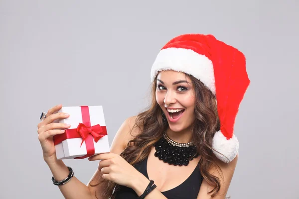 Vrouw in Kerstman hoed bedrijf geschenken, geïsoleerd op grijze achtergrond — Stockfoto