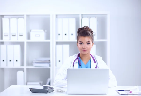 Kobieta lekarz siedzi na biurku i pracuje na laptopie w szpitalu — Zdjęcie stockowe