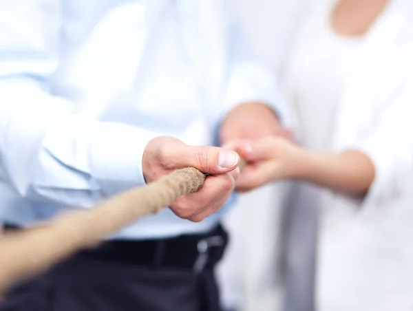 Konzeptbild eines Geschäftsteams, das ein Seil als Element der Teamarbeit im Vordergrund verwendet — Stockfoto