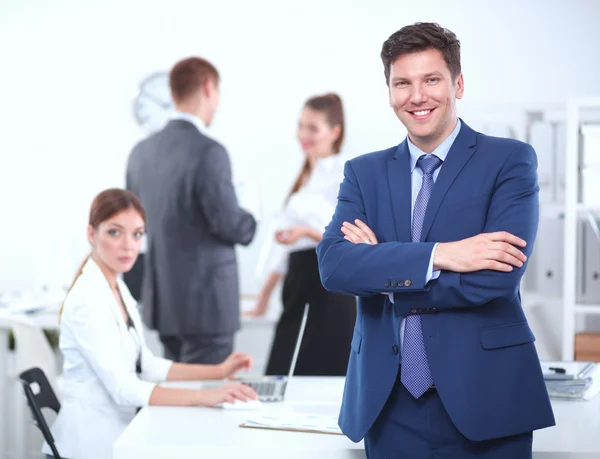 Uomo d'affari di successo in piedi con il suo personale in background in ufficio — Foto Stock