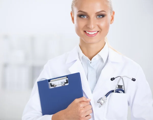 Sorridente medico donna con una cartella in uniforme in piedi in ospedale — Foto Stock