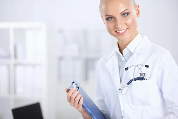 Улыбающаяся женщина-врач с папкой в форме, стоящей в больнице — стоковое фото