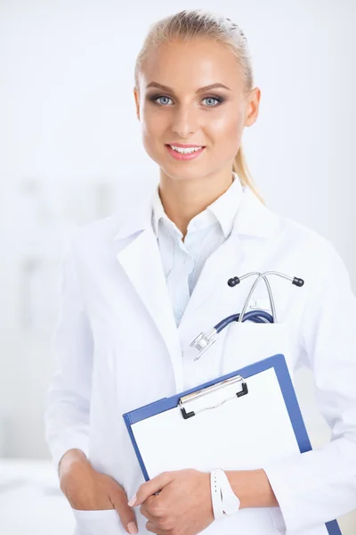 Médico sonriente con una carpeta en uniforme de pie en el hospital —  Fotos de Stock