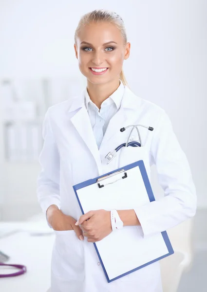 Lächelnde Ärztin mit Ordner in Uniform steht im Krankenhaus — Stockfoto