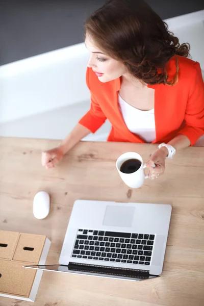 Belle femme assise au bureau, travaillant avec un ordinateur portable — Photo