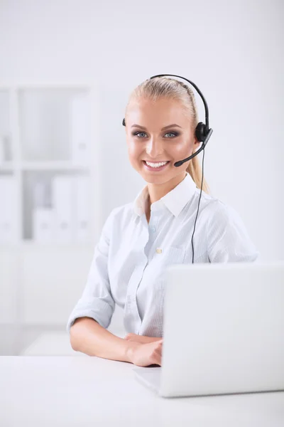 Retrato de una hermosa mujer de negocios trabajando en su escritorio con auriculares y laptop —  Fotos de Stock