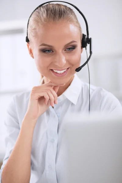 Retrato de una hermosa mujer de negocios trabajando en su escritorio con auriculares y laptop — Foto de Stock