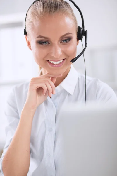 Retrato de una hermosa mujer de negocios trabajando en su escritorio con auriculares y laptop — Foto de Stock