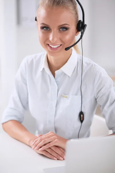 Portrait of beautiful businesswoman working at her desk with headset and laptop — Stock Photo, Image