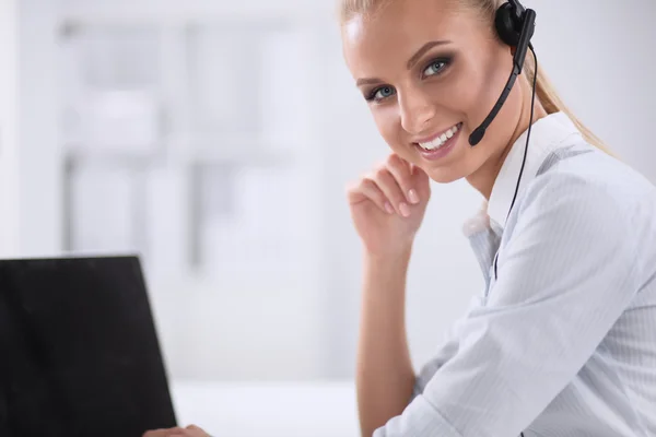 Retrato de una hermosa mujer de negocios trabajando en su escritorio con auriculares y laptop — Foto de Stock