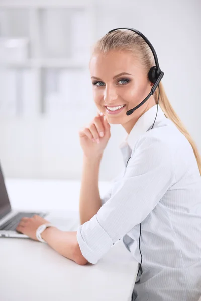 Retrato de una hermosa mujer de negocios trabajando en su escritorio con auriculares y laptop — Foto de Stock