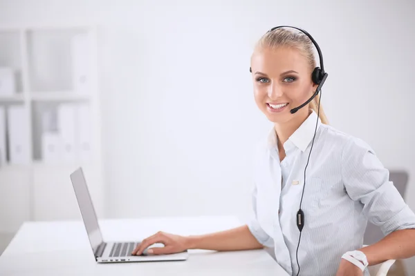 Retrato de una hermosa mujer de negocios trabajando en su escritorio con auriculares y laptop — Foto de Stock