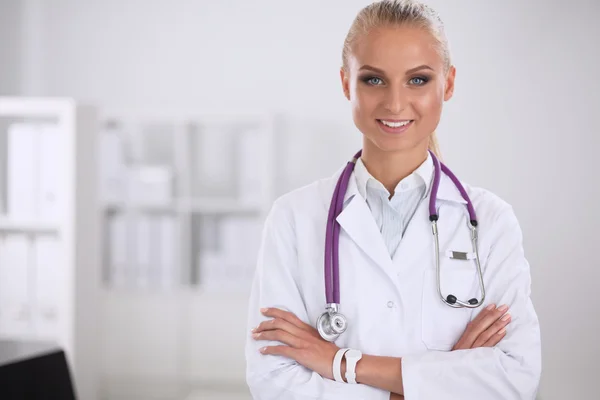 Portrait of young woman doctor with white coat standing in hospital — Stock Photo, Image