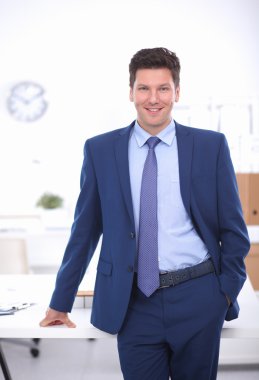 Kendine güvenen başarılı genç işadamı eğilimli silah masasının üzerindeki