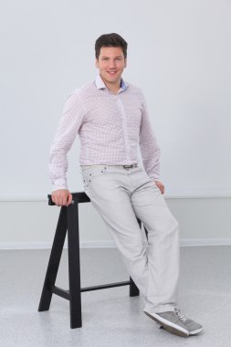 gri arka plan üzerinde duran, zeki genç bir adam portresi