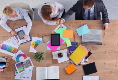 İş adamları iş toplantısında, ofiste oturup tartışıyorlar.