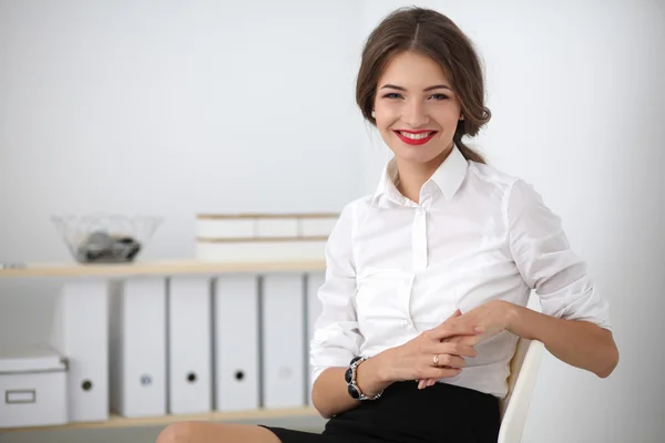 Attraktive Geschäftsfrau sitzt im Büro — Stockfoto