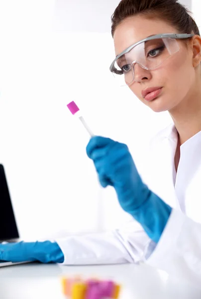 Woman researcher is surrounded by medical vials and flasks, isolated on white background — Stock Photo, Image