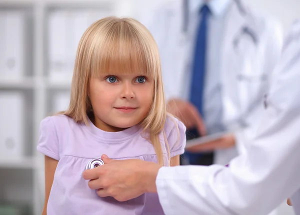 Female doctor examining child with stethoscope at surgery — Stock Photo, Image