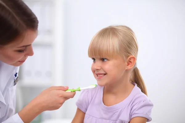 Tandarts en klein meisje in het tandartspraktijk. — Stockfoto