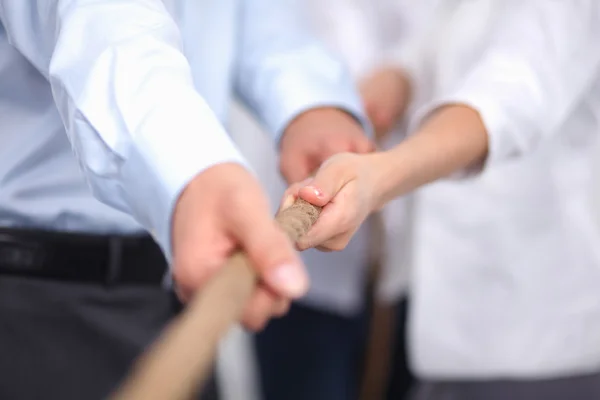 Konzeptbild eines Geschäftsteams, das ein Seil als Element der Teamarbeit im Vordergrund verwendet — Stockfoto