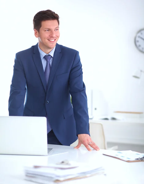 Vertrouwen succesvolle jonge zakenman leunend wapens op zijn Bureau — Stockfoto