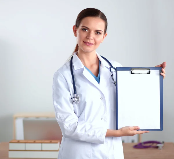 Sorridente medico donna con una cartella in uniforme in piedi in ospedale — Foto Stock