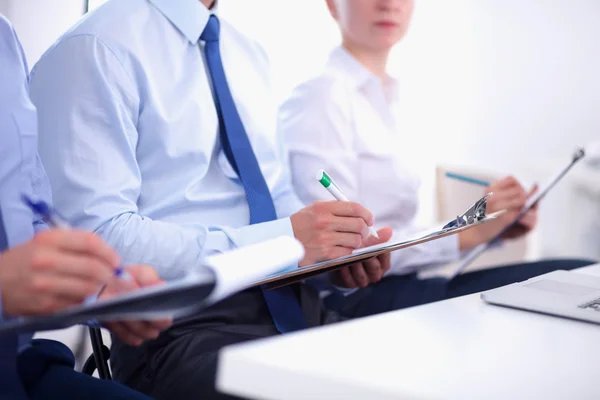 Uomini d'affari seduti e che scrivono alla riunione di lavoro, in ufficio — Foto Stock