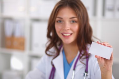 Kadın doktor elinde boş bir kart tutuyor, beyaz arka planda izole edilmiş.