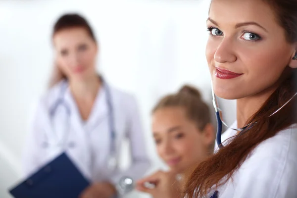 Médico sonriente con una carpeta en uniforme de pie en el hospital — Foto de Stock