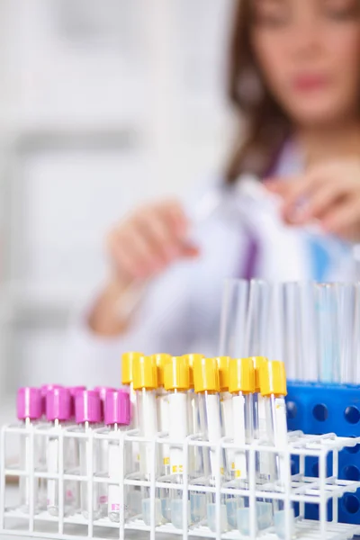 Női kutató körül orvosi injekciós üvegek és flaskák, elszigetelt fehér alapon — Stock Fotó