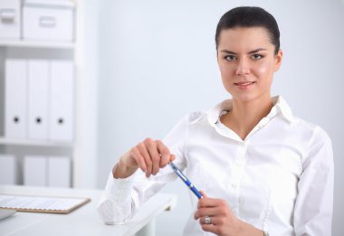 Ofiste dizüstü bilgisayarı olan çekici bir iş kadını.