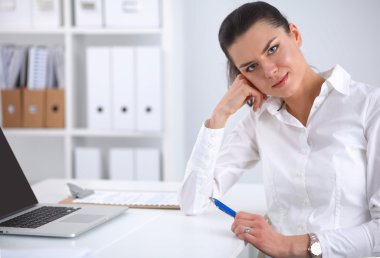 Ofiste dizüstü bilgisayarı olan çekici bir iş kadını.