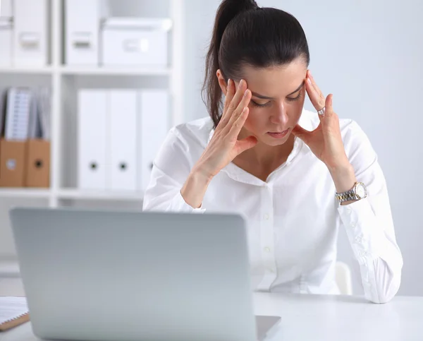 yorgun bir genç iş kadını ofiste dizüstü bilgisayar ile portresi