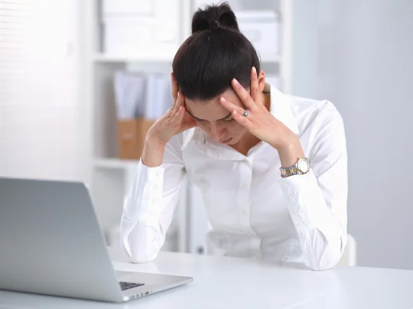 Portrait of tired young business woman with laptop at the office — Stock Photo, Image