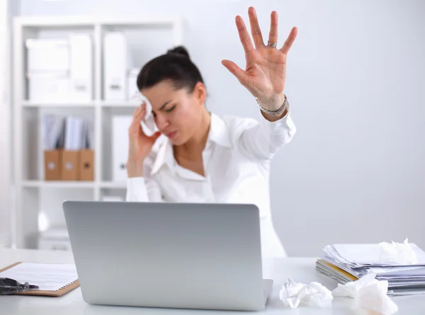 Junge Geschäftsfrau pustet sich die Nase, sitzt am Schreibtisch — Stockfoto