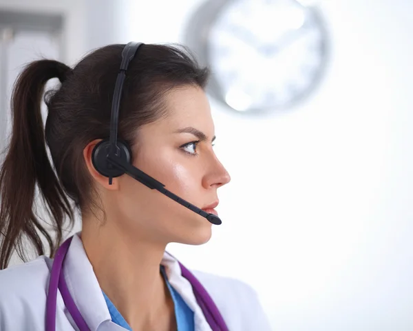 Dokter draagt een headset zittend achter een bureau met laptop — Stockfoto