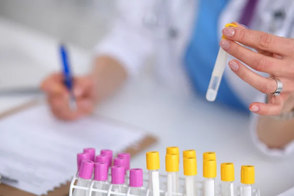 Woman researcher is surrounded by medical vials and flasks, isolated on white background — Stock Photo, Image