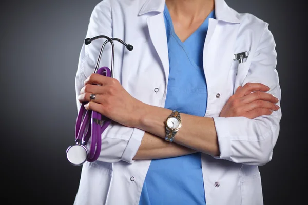 Portrait of young female doctor holding a stethoscope, isolated on black background — Stock Photo, Image