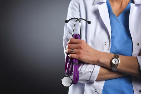 Portrait of young female doctor holding a stethoscope, isolated on black background — Stock Photo, Image