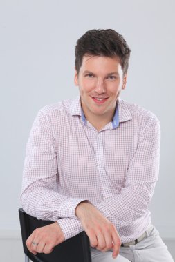 gri arka plan üzerinde duran, zeki genç bir adam portresi