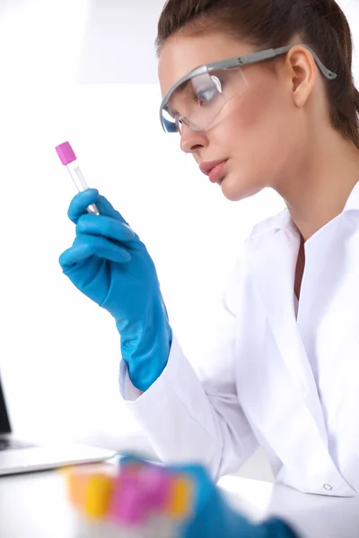 Woman researcher is surrounded by medical vials and flasks, isolated on white background — Stock Photo, Image