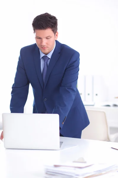 Vertrouwen succesvolle jonge zakenman leunend wapens op zijn Bureau — Stockfoto